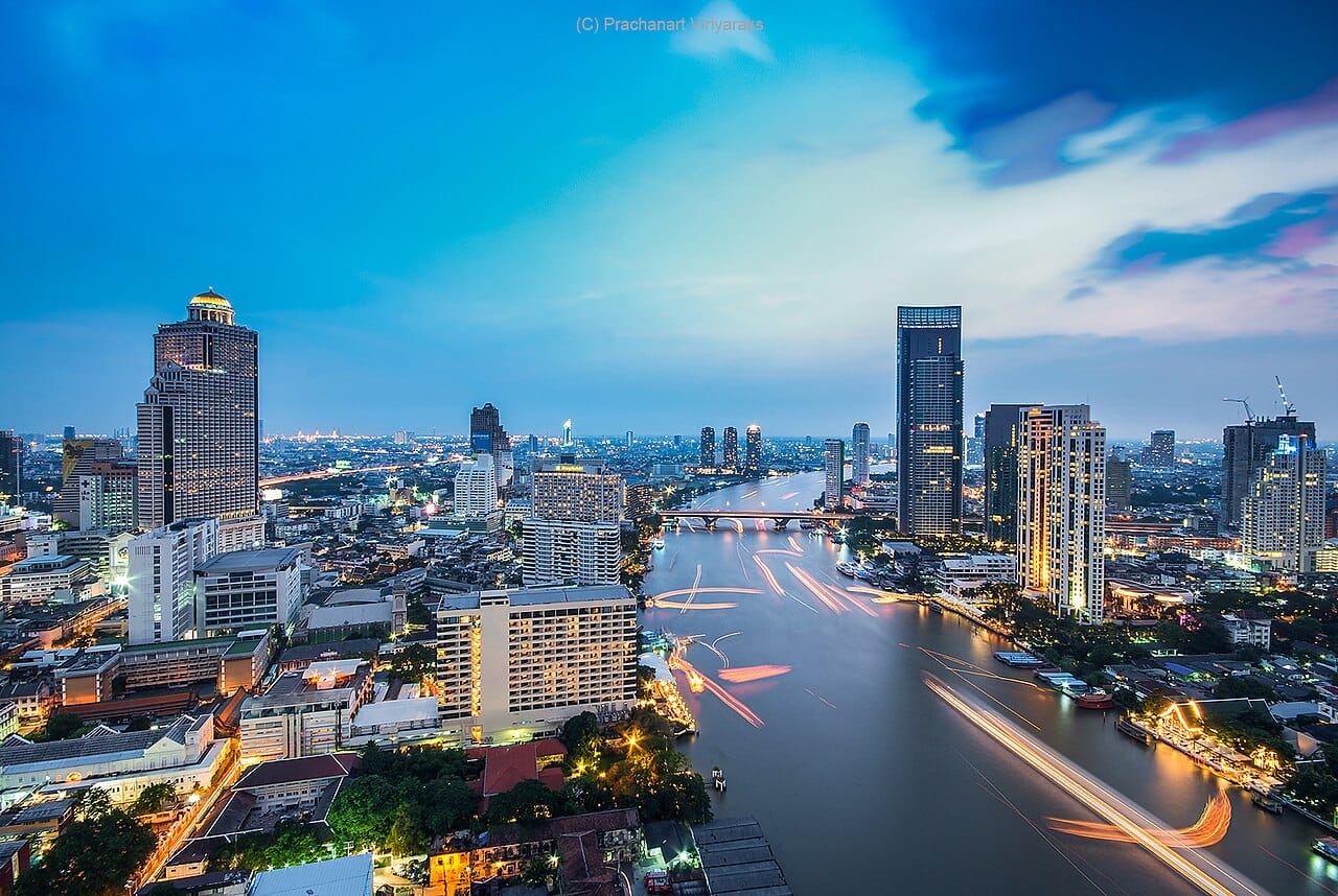 Chao Phraya River winding past riverside hotels in Bangkok at dusk