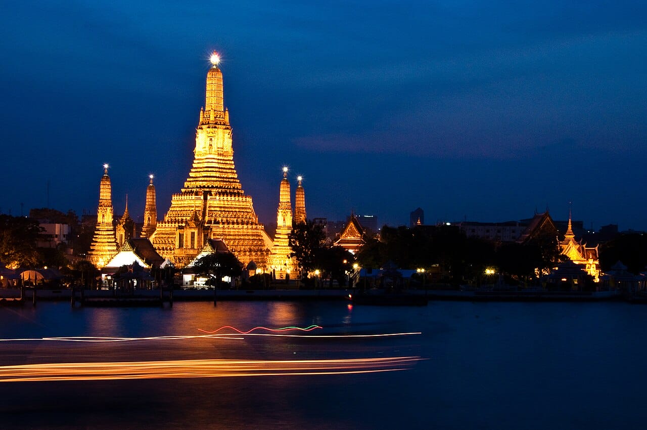 Wat Arun, the Temple of Dawn, lit up at night across the Chao Phraya River